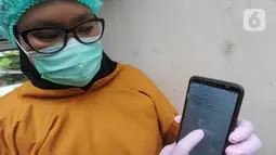 Paramedis menunjukkan SMS undangan mengikuti kegiatan vaksin Covid-19 di Puskesmas  Ciganjur, Jakarta Selatan, Kamis (7/1/2021). Kemenkes telah mengirimkan SMS blast kepada para penerima vaksin tahap pertama, terutama kepada tenaga kesehatan. (merdeka.com/Arie Basuki)