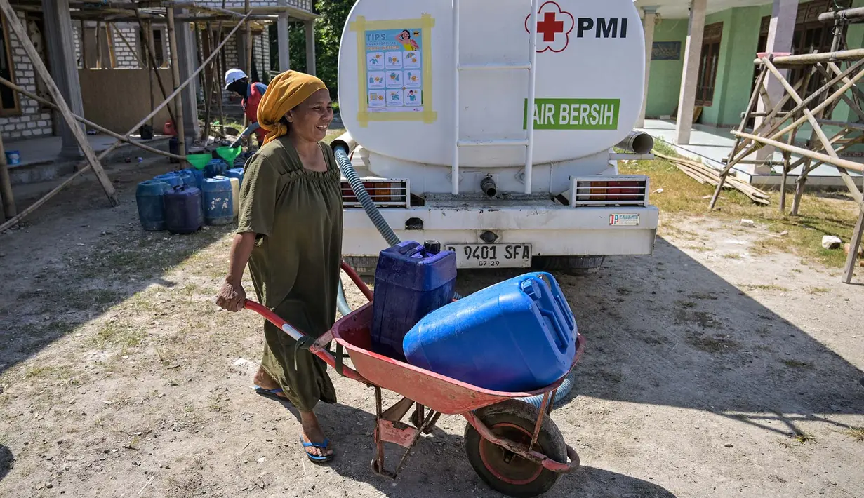 Warga membawa jeriken berisi air bersih yang didistribusikan oleh Palang Merah Indonesia (PMI) Kabupaten Bangkalan di Dusun Batangan Tengah, Desa Batangan, Kecamatan Tanah Merah, Kabupaten Bangkalan, Jawa Timur, Selasa (21/7/2026). (AFP/ Juni Kriswanto