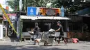 Sebanyak sembilan kios dan delapan kendaraan hangus terbakar. Tampak dalam foto, pemilik kios membersihkan puing-puing bangunan usai kebakaran yang melanda deretan kios di kawasan Kalibata, Jakarta Selatan, pada Jumat (12/12/2025). (merdeka.com/magang/Rendi Saputra)