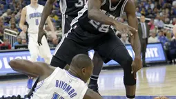 Pemain Spurs, Livio Jean-Charles #28 berebut bola dengan pemain Orlando Magic, Bismack Biyombo #11 pada laga NBA preseason basketball di Orlando. (AP/John Raoux)