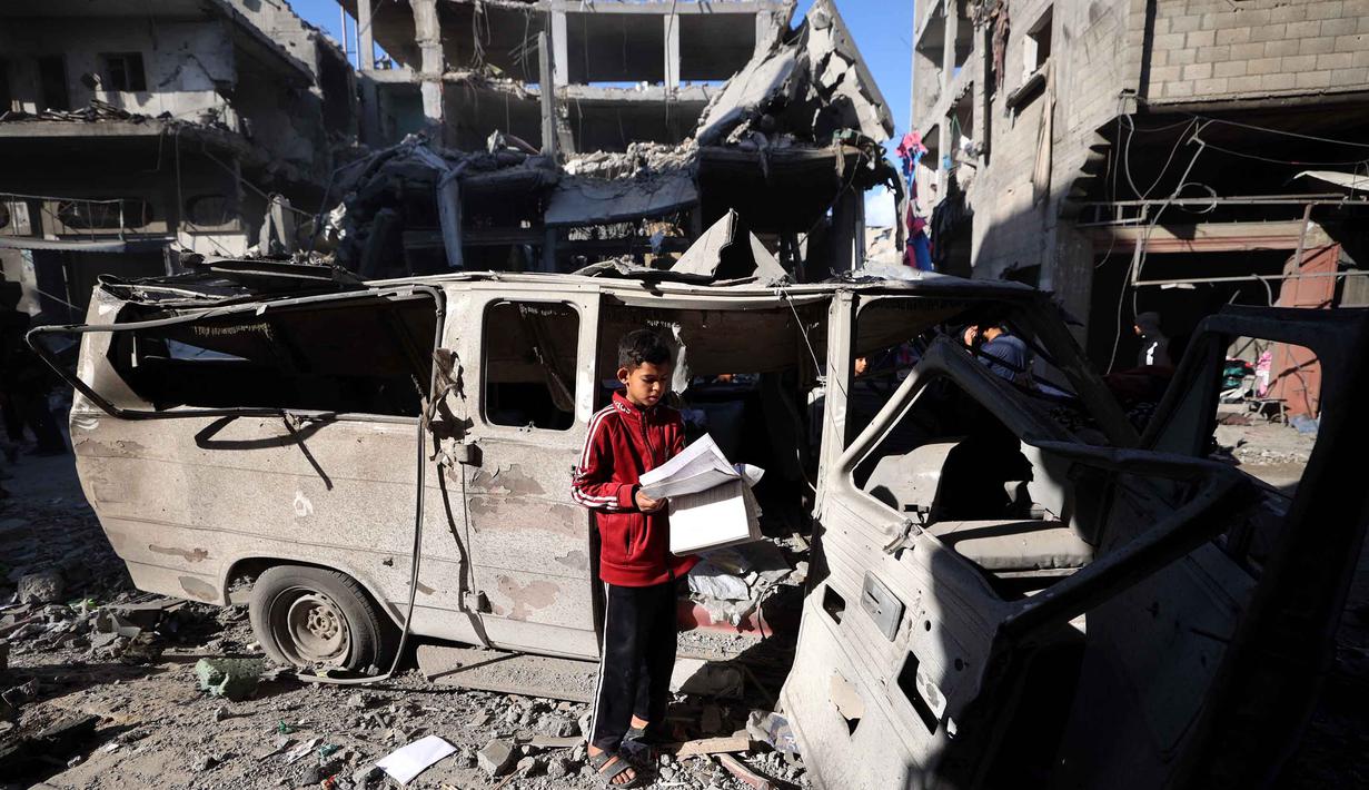 Seorang anak pengungsi Palestina berdiri di dekat bangunan yang rusak akibat serangan Israel di kamp pengungsi Maghazi, Jalur Gaza Tengah pada Kamis 21 Mei 2026. (Eyad Baba/AFP)