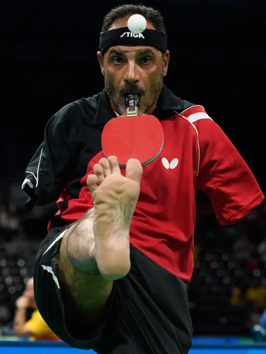 Aksi atlet Mesir, Ibrahim Hamadtou saat bersiap melempar bola dengan bantuan kakinya ke arah lawannya, Thoma Rau (Jerman) pada cabang tenis meja tunggal putra di ajang Paralimpiade 2016, Rio de Janeiro, 9 September 2016. (Thomas Lovelock/OIS/IOC via AFP)