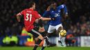 Striker Everton Yannick Bolasie berusaha melewati pemain tengah Manchester United, Nemanja Matic saat pertandingan Liga Inggris di Goodison Park, Liverpool (1/1). Everton harus menelan kekalahan 0-2 atas Manchester United. (AFP Photo/Paul Ellis)