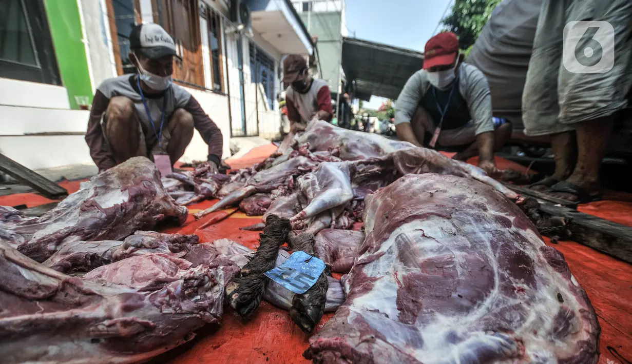 Panitia memotong daging hewan kurban saat perayaan Hari Raya Idul Adha 1442 H di Musala Nurul Huda, Jakarta, Selasa (20/7/2021). Panitia diwajibkan mengenakan masker dan menerapkan protokol kesehatan guna mencegah penyebaran COVID-19. (merdeka.com/Iqbal S. Nugroho)