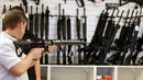 Calon pembeli saat memegang senapan serbu AR-15 di toko senjata "Ready Gunner", Utah, AS, (21/6). Peningkatan penjualan justru muncul ketika pemerintah membicarakan untuk melarang penjualan beberapa jenis senjata. (REUTERS/George Frey)