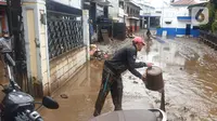 Warga membersihkan lumpur sisa dari banjir bandang Garut di kawasan Cimacan, Desa Jayaraga, Kecamatan Tarogong Kidul, Sabtu (16/7/2022). Pemda Garut, Jawa Barat menyatakan status darurat banjir setelah 8 kecamatan di wilayah tersebut terendam banjir usai Sungai Cimanuk dan beberapa anak sungainya meluap. (Liputan6.com/Jayadi Supriadin)
