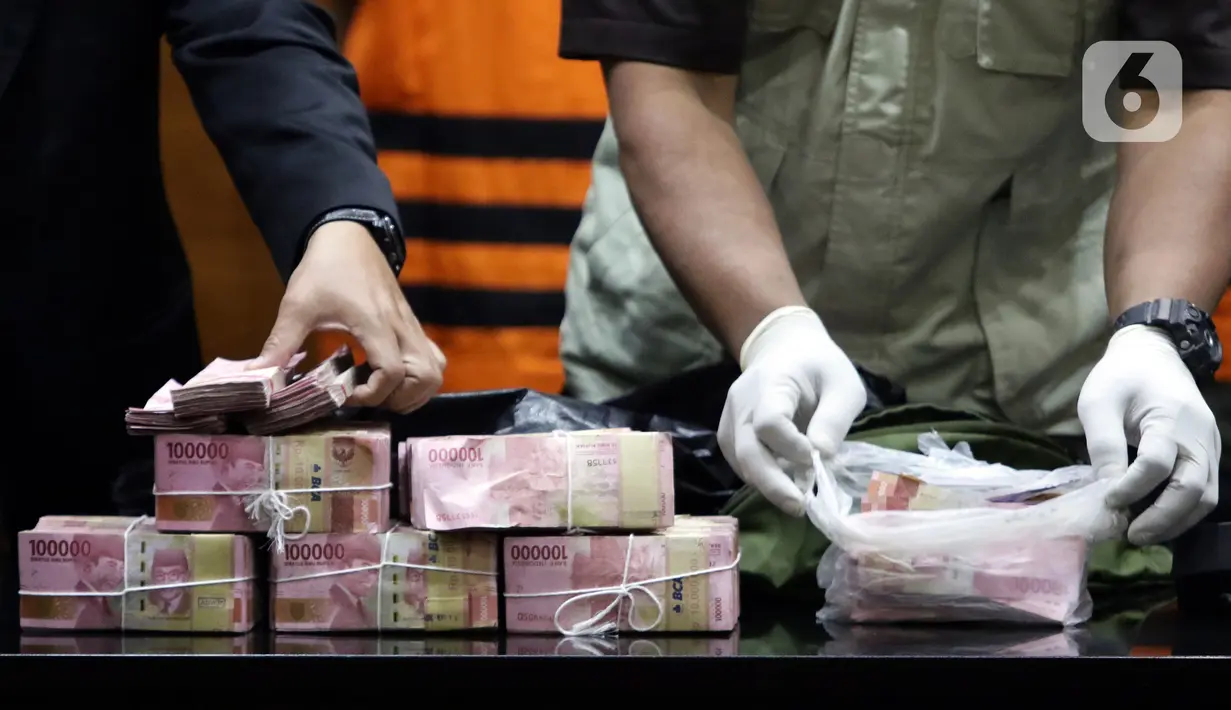 Petugas menunjukkan barang bukti hasil OTT Bupati Langkat, Terbit Rencana Perangin Angin saat rilis penahanan tersangka di Gedung KPK, Jakarta, Kamis (20/1/2022). KPK resmi menahan Bupati Langkat, Terbit Rencana Perangin Angin dan menyita uang sebesar Rp 786 juta. (Liputan6.com/Helmi Fithriansyah)