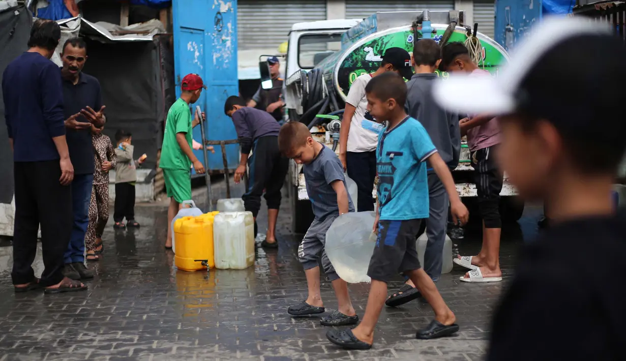 Anak laki-laki Palestina membawa jeriken berisi air dari titik distribusi di kamp pengungsi Bureij, Jalur Gaza tengah pada 28 April 2025. (Eyad BABA/AFP)