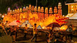 Warga mengikuti parade bersama perahu naga di Luang Prabang, Laos, 3 Oktober 2020. Dalam Festival Boun Lai Heua Fai, warga mendandani kota dengan berbagai lentera, berparade bersama, kemudian melarungkan perahu naga besar dan kecil dari batang pohon pisang ke Sungai Mekong. (Xinhua/Kaikeo Saiyasane)