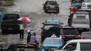 Petugas keamanan mengatur arus lalu lintas saat banjir merendam kawasan Gambir, Jakarta, Kamis (15/2). Banjir tersebut mengakibatkan jalan di sekitar lokasi terpaksa ditutup karena tidak bisa dilalui kendaraan bermotor.(Liputan6.com/Johan Tallo)