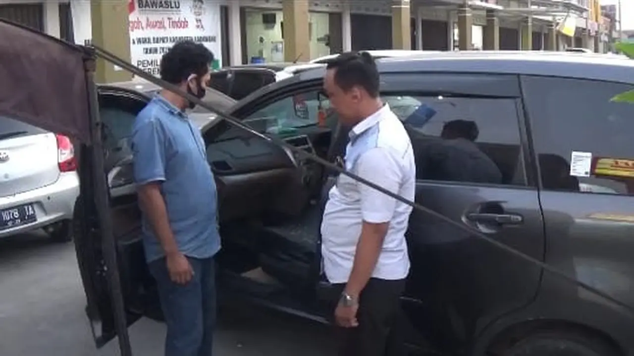 Mobil anggota Bawaslu Karawang dibobol maling dengan modus pecah ban di dekat tenda pengamanan polisi. (Foto: Liputan6.com/Abramena)