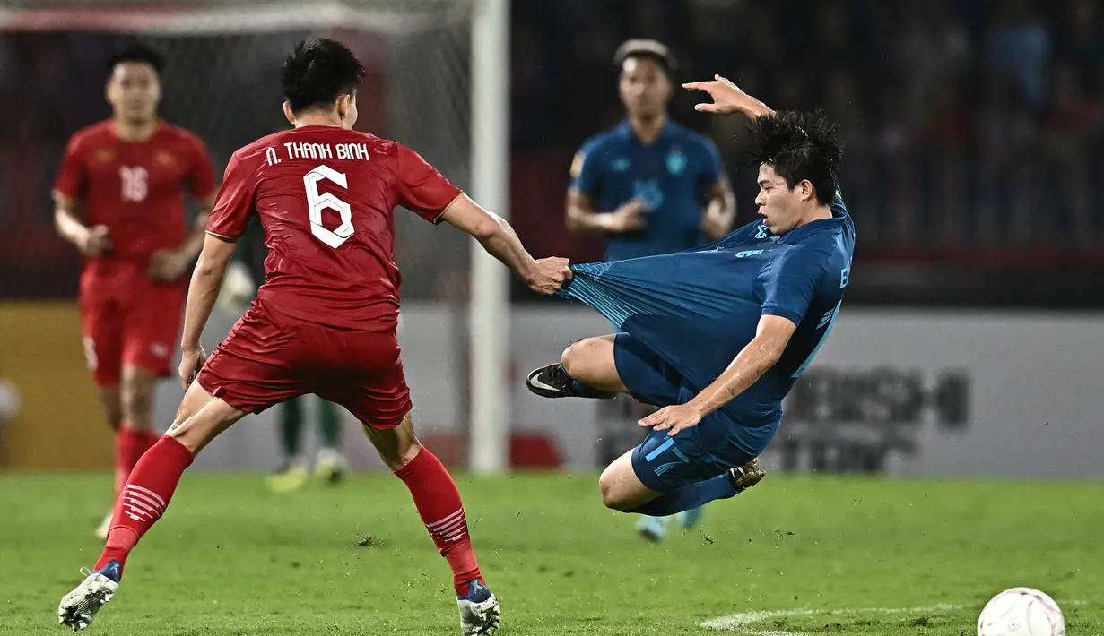 Pemain Thailand, Ekanit Panya (kanan) dilanggar pemain Vietnam, Nguyen Thanh Binh pada laga final Piala AFF 2022 di Thammasat Stadium, Bangkok, Thailand (16/1/2023). Bersama Timnas Thailand, Ekanit Panya telah mengoleksi 17 caps dengan torehan 1 gol dan 4 assist sejak melakukan debut pada 10 September 2019. (AFP/Lillian Suwanrumpha)