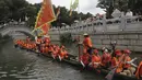 Peserta perahu naga dari desa Panting mendayung di sepanjang kanal di kawasan bersejarah Teluk Lychee di Guangzhou di Provinsi Guangdong, China selatan, Jumat, 3 Juni 2022. Perlombaan perahu naga kembali digelar di beberapa bagian China untuk pertama kalinya sejak merebaknya pandemi pada akhir 2019, saat pembatasan dicabut bersama dengan penurunan besar  kasus COVID-19. (AP Photo/Caroline Chen)