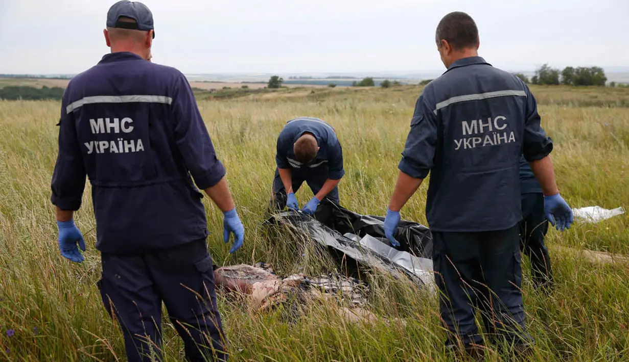 Tim penyidik Ukraina tampak menyiapkan kantong mayat untuk membawa jenazah dan sisa barang-barang dari puing Malaysia Airlines MH-17 (REUTERS/Maxim Zmeyev)