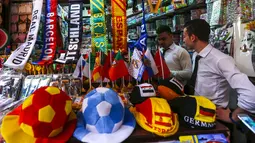 Pembeli mencari pernak-pernik negara-negara yang berpartisipasi pada Piala Dunia FIFA 2018 di jalan pasar di kota tua Damasku, Suriah (6/6). Piala Dunia akan digelar pada 14 Juni 2018 di Rusia. (AFP Photo/Louai Beshara)
