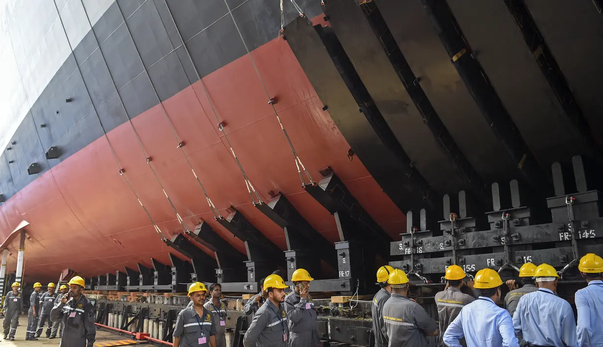 Para pekerja bersiap untuk upacara peluncuran kapal perang INS Udaygiri di halaman Mazagaon Dock Shipbuilders Limited, Mumbai, India, Selasa (17/5/2022). (Punit PARANJPE/AFP)