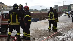 Petugas pemadam kebakaran berjaga di lokasi jalanan yang ambles di dekat sungai Arno di Lungarno Torrigiani, Florence, Italia (25/5). Kejadian tersebut disebabkan oleh pecahnya pipa besar saluran air. (AFP PHOTO/CLAUDIO GIOVANNINI)