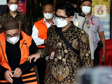 Petugas menggiring dua tersangka dugaan korupsi pekerjaan pembangunan Stadion Mandala Krida Daerah Istimewa Yogyakarta menuju mobil tahanan di Gedung KPK, Jakarta, Kamis (21/7/2022). KPK menahan Direktur Utama PT Arsigraphi, Sugiharto (kedua kiri depan) dan Kabid Pendidikan Khusus Dinas Pendidikan, Pemuda dan Olahraga DIY, Edy Wahyudi. (Liputan6.com/Helmi Fithriansyah)