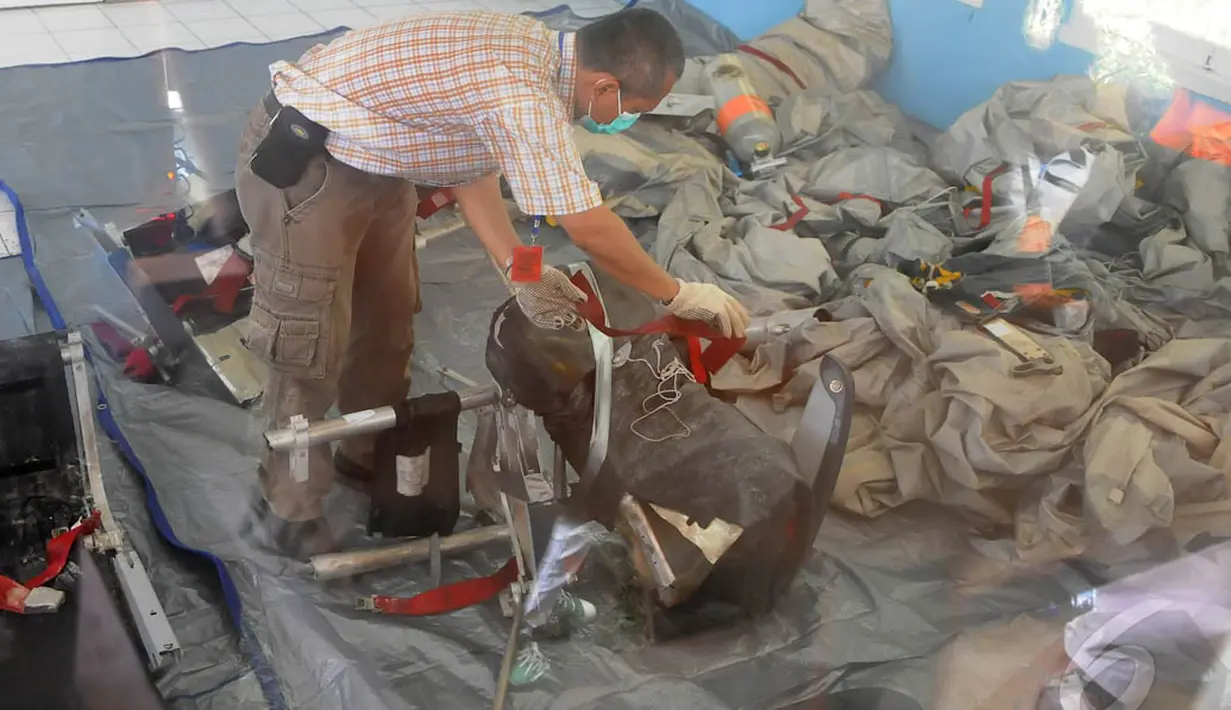 Petugas KNKT saat melakukan pemeriksaan serpihan pesawat AirAsia QZ8501 di posko DVI Lanud TNI AU Iskandar, Pangkalan Bun, Selasa (6/1/15). (Liputan6.com/Herman Zakharia)