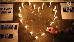 Lilin simbol cinta dinyalakan oleh gabungan suporter klub sepak bola dalam aksi solidaritas terkait tragedi teror bom di Surabaya dan Sidoarjo di Taman Suropati, Jakarta, Senin (14/5). (Liputan6.com/Immanuel Antonius)