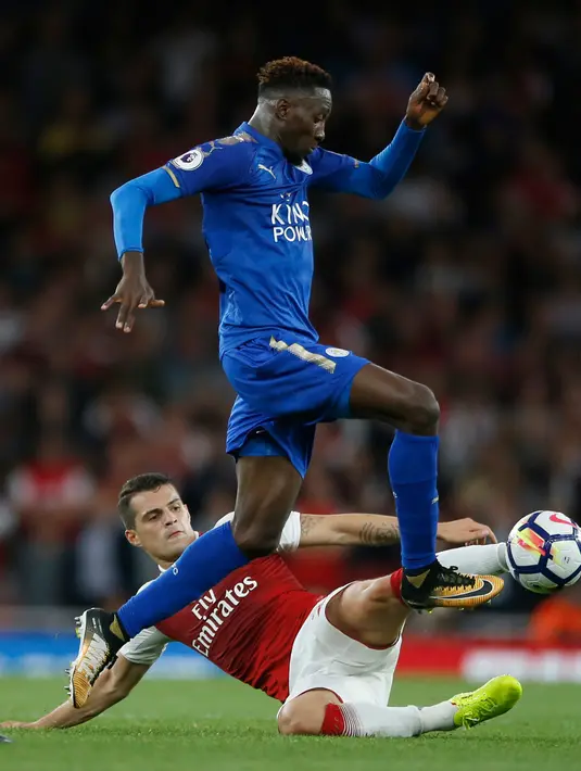Pemain Leicester City, Wilfred Ndidi berusaha melewati pemain Arsenal Granit Xhaka saat pertadingan Liga Inggris di  Stadion Emirates, London (11/8). (AP Photo/Alastair Grant)