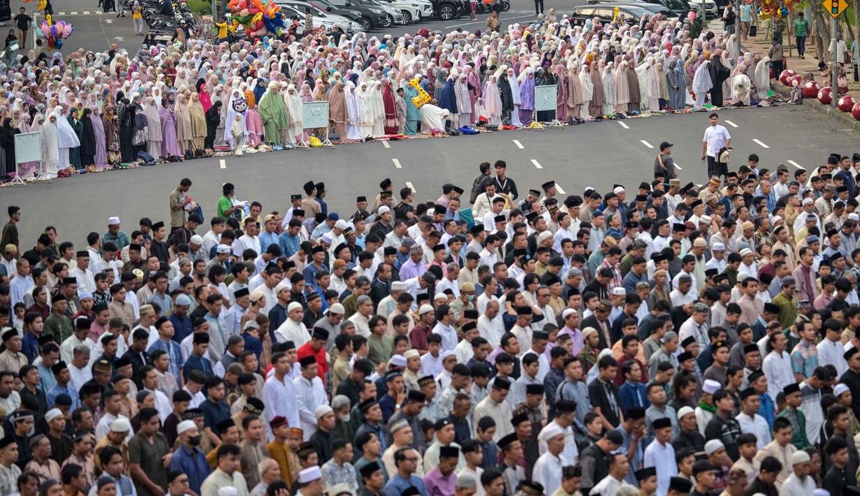 Pemerintah Indonesia melalui Kementerian Agama menetapkan 1 Syawal 1444 Hijriah jatuh pada Sabtu 21 Maret 2026. Tampak dalam foto, umat muslim saat melaksanakan salat Idul Fitri 1447 Hijriah di salah satu ruas jalan di kota Surabaya, Jawa Timur, pada Jumat 20 Maret 2026. (JUNI KRISWANTO/AFP)