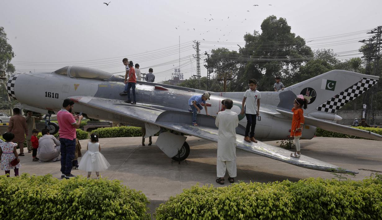 <p>Anak-anak bermain model pesawat tempur di titik piknik untuk merayakan hari raya Idul Fitri, membuat di penghujung bulan puasa Ramadhan, di Lahore, Pakistan, Rabu, 4 Mei 2022. (AP Photo/K.M. Chaudary)</p>