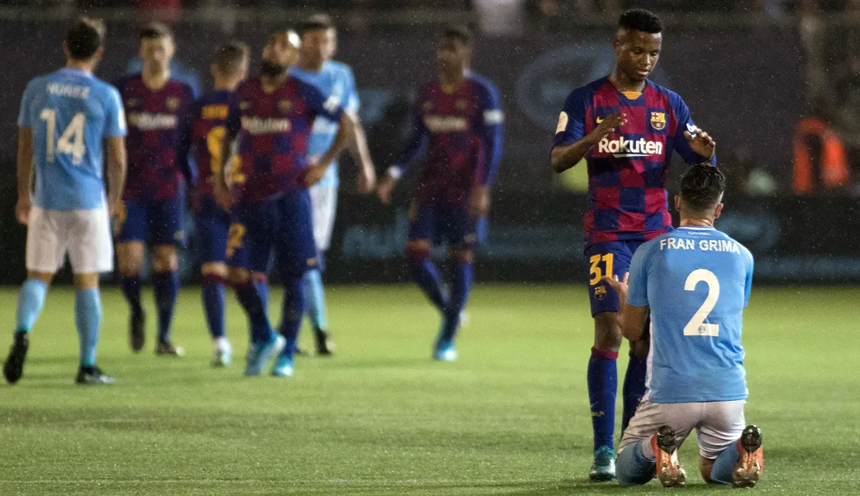 Wonderkid Barcelona, Ansu Fati (kedua kanan) menghibur pemain UD Ibiza, Fran Grima pada akhir pertandingan babak 32 besar Copa del Rey 2019-2020 di Estadi Municipal de Can Misses, Rabu (21/1/2020). Barcelona harus bersusah payah untuk mengalahkan Klub Segunda B UD Ibiza 2-1. (JAIME REINA/AFP)