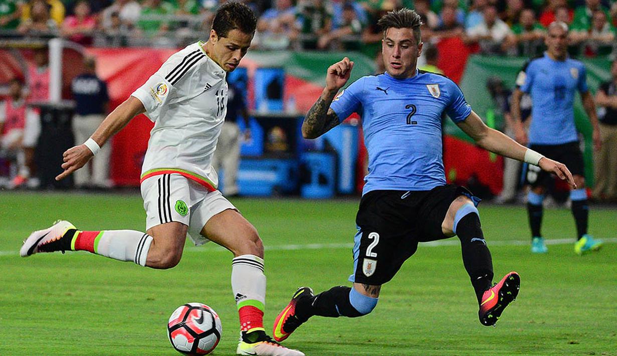 Penyerang Meksiko, Javier Hernandez, berusaha melewati  bek Uruguay, Jose Gimenez, pada laga Grup C Copa Amerika. Sementara satu-satunya gol Uruguay diciptakan oleh Diego Godin. (AFP/Jennifer Stewart)