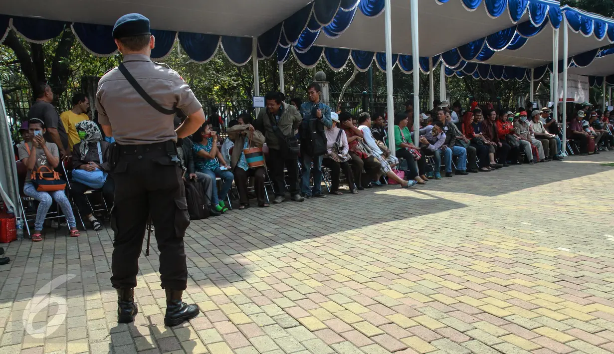 Anggota polisi mengamankan lokasi penukaran uang receh di Monas, Jakarta, Selasa (30/6/2015). Bank Indonesia bekerjasama dengan 14 bank lainnya membuka loket penukaran uang pecahan kecil sejak 17 Juni-15 Juli 2015. (Liputan6.com/Faizal Fanani)