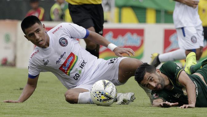 Gelandang Arema FC, Hanif Sjahbandi, berebut bola dengan striker Persebaya, Manuchehr Jalilov, pada laga final Piala Presiden 2019 di Stadion Gelora Bung Tomo, Surabaya, Selasa (9/4). Kedua tim bermain imbang 2-2. (Bola.com/Yoppy Renato)