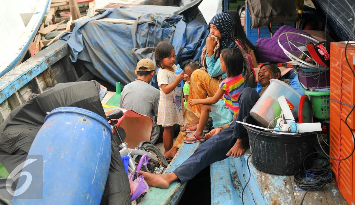 Sejumlah penghuni Pasar Ikan, Penjaringan mengungsi ke perahu nelayan untuk menyelamatkan barang-barang saat pembongkaran, Jakarta, Senin (11/4). Pemprov DKI membongkar ratusan rumah di wilayah Pasar Ikan. (Liputan6.com/Yoppy Renato)