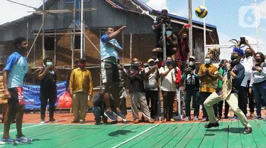 Menteri Pariwisata dan Ekonomi Kreatif (Parekraf) / Kepala Badan Pariwisata dan Ekonomi Kreatif  Sandiaga Salahuddin Uno (kanan) bermain bola voli bersama warga di Kampung Yoboi, kawasan Danau Sentani, Kabupaten Jayapura, Papua, Selasa (21/9/2021). (Liputan6.com/HO/Parekraf)