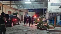 Polisi bersenjata lengkap mengawal penyidik KPK menggeledah rumah pengusaha terkait korupsi proyek jalan di Bengkalis. (Liputan6.com/M Syukur)