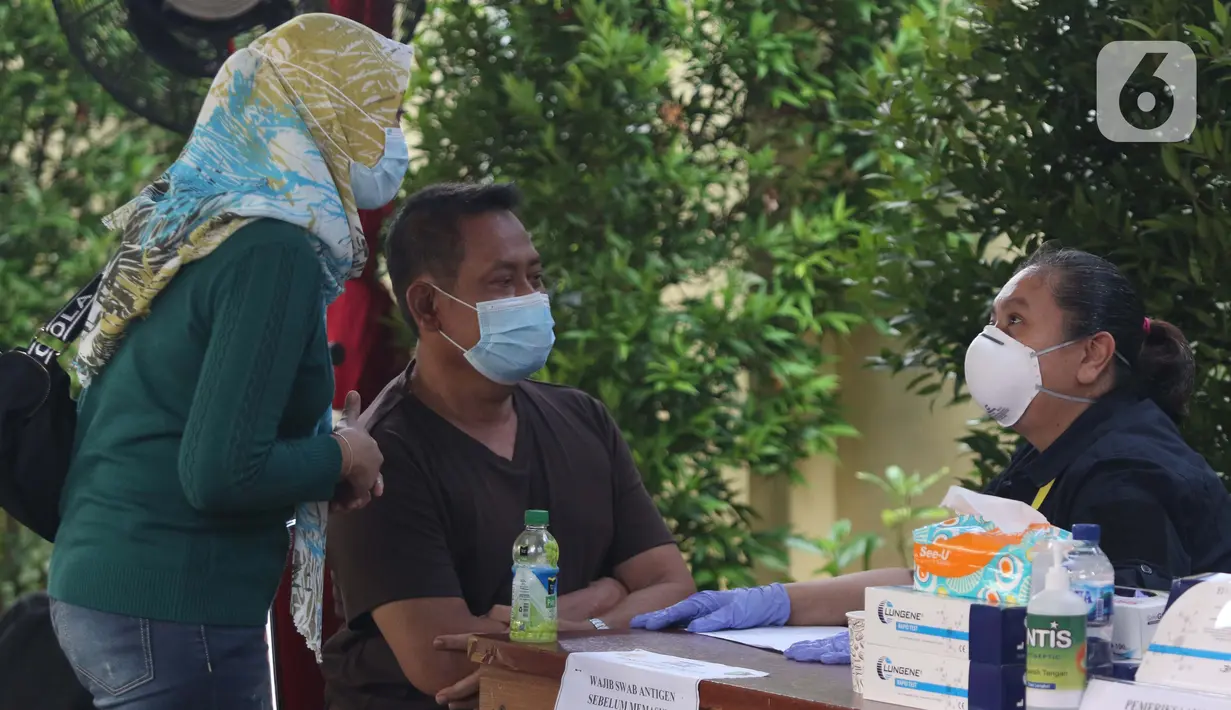 Supeno Hendri Kiswanto (tengah), ayah dari Okky Bisma korban kecelakaan pesawat Sriwijaya Air SJ 182, saat mengurus pengambilan jenazah Okky Bisma di Posko Ante Mortem, RS Bhayangkara RS Sukanto, Jakarta, Rabu (13/1/2021). Jenazah akan diambil pada Kamis (14/1). (Liputan6.com/Helmi Fithriansyah)
