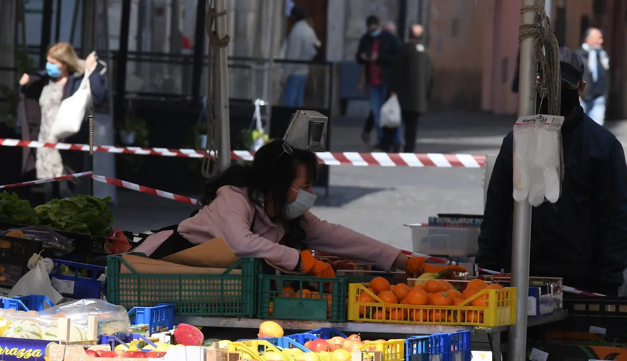 Pedagang buah-buahan mengenakan masker saat berjualan di sebuah pasar di Roma, Italia, 6 April 2020. Menurut Departemen Perlindungan Sipil Italia pada 6 April 2020, jumlah kasus virus corona COVID-19 di negara tersebut menjadi 132.547 dengan angka kematian mencapai 16.523. (Xinhua/Augusto Casasoli)
