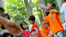 Aksi seorang bocah akan menerbangkan pesawat kayu di acara "Save   Our Children", Jakarta, Minggu (23/11/2014) (Liputan6.com/Faisal R   Syam)
