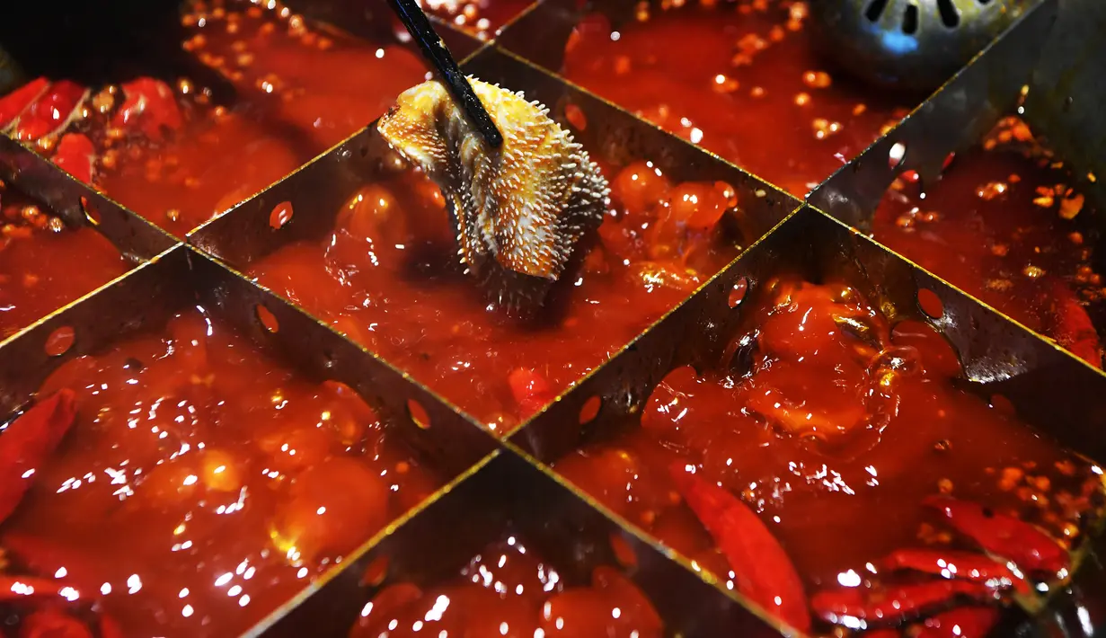Seorang pembeli menikmati makanan di sebuah restoran hot pot di Chongqing, China barat daya, pada 5 Oktober 2020. Masyarakat di seluruh China menikmati beragam makanan lezat selama libur Hari Nasional dan Festival Pertengahan Musim Gugur. (Xinhua/Wang Quanchao)