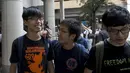 Joshua Wong (kiri) berbincang denga dua rekannya di luar pengadilan, Hong Kong, Cina, Jumat (28/8/2015). Joshua Wong, Nathan Law, dan Chow. Mereka dituntut atas tuduhan memanjat pagar kompleks gedung pemerintah pada awal demonstrasi. (REUTERS/Tyrone Siu)