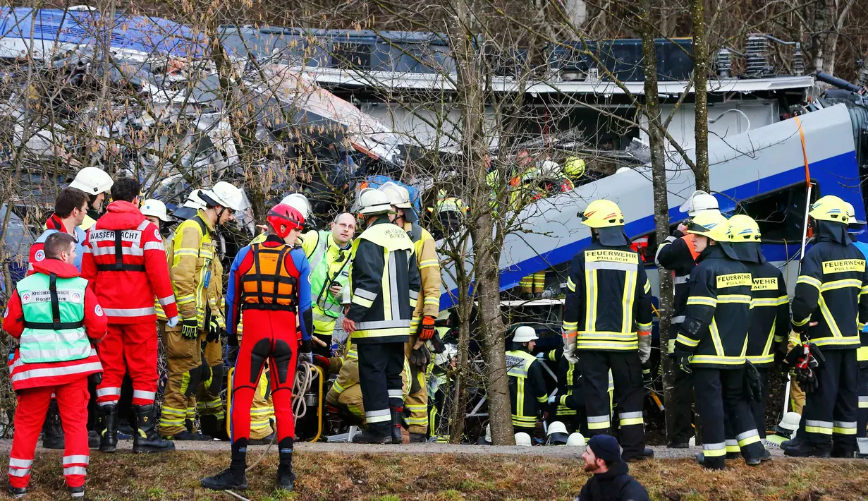 Regu penyelamat berusaha mengevakuasi korban tabrakan antara dua kereta di dekat Bad Aibling, Jerman, Selasa (9/2). Beberapa penumpang dilaporkan masih terjebak di dalam puing-puing gerbong. (REUTERS/Michael Dalder)