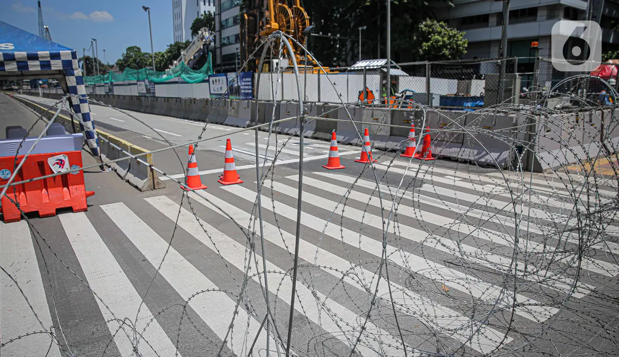 Barikade kawat berduri terpasang di kawasan Jalan MH Thamrin, Jakarta, Kamis (2/12/2021). Polda Metro Jaya memasang barikade di sejumlah titik menuju kawasan Patung Kuda-Monumen Nasional (Monas) Jakarta Pusat guna mengantisipasi kerumunan massa aksi Reuni 212. (Liputan6.com/Faizal Fanani)