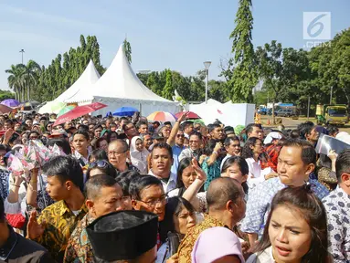 Warga mengantre di kawasan Silang Monas, untuk mengikuti Open House Jokowi di Istana Kepresidenan, Jakarta Rabu (5/6/2019). Warga mulai rela antre setelah Salat Id meski Istana baru dibuka pada pukul 10.00 WIB. (Liputan6.com/HO/Grandy)