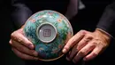 Tampak bawah mangkuk Dinasti Qing saat dipamerkan di Rumah Lelang Sotheby's di Hong Kong, Kamis (2/3). Mangkuk berdiameter 14,7 centimeter ini berwarna merah muda dan biru dengan hiasan cat halus. (ANTHONY WALLACE/AFP)
