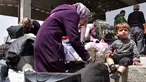 Seorang anak duduk di dekat ibunya saat sampai di sebuah tempat penampungan sementara di Jibrin di pinggiran timur Aleppo, Jumat (21/4). Pengungsi adalah warga dari kota Fuaa dan Kafraya. (AFP PHOTO / George OURFALIAN)