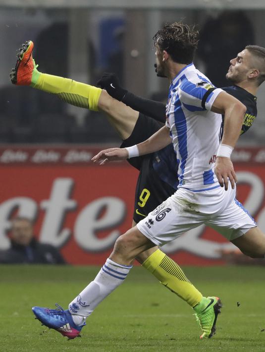 Aksi pemain nter Milan, Mauro Icardi (kanan) saat berebut bola dengan pemain Pescara, Guglielmo Stendardo pada laga lanjutan Serie A di  Giuseppe Meazza stadium, Milan (28/1/2017). Inter menang 3-0.  (AP /Luca Bruno)