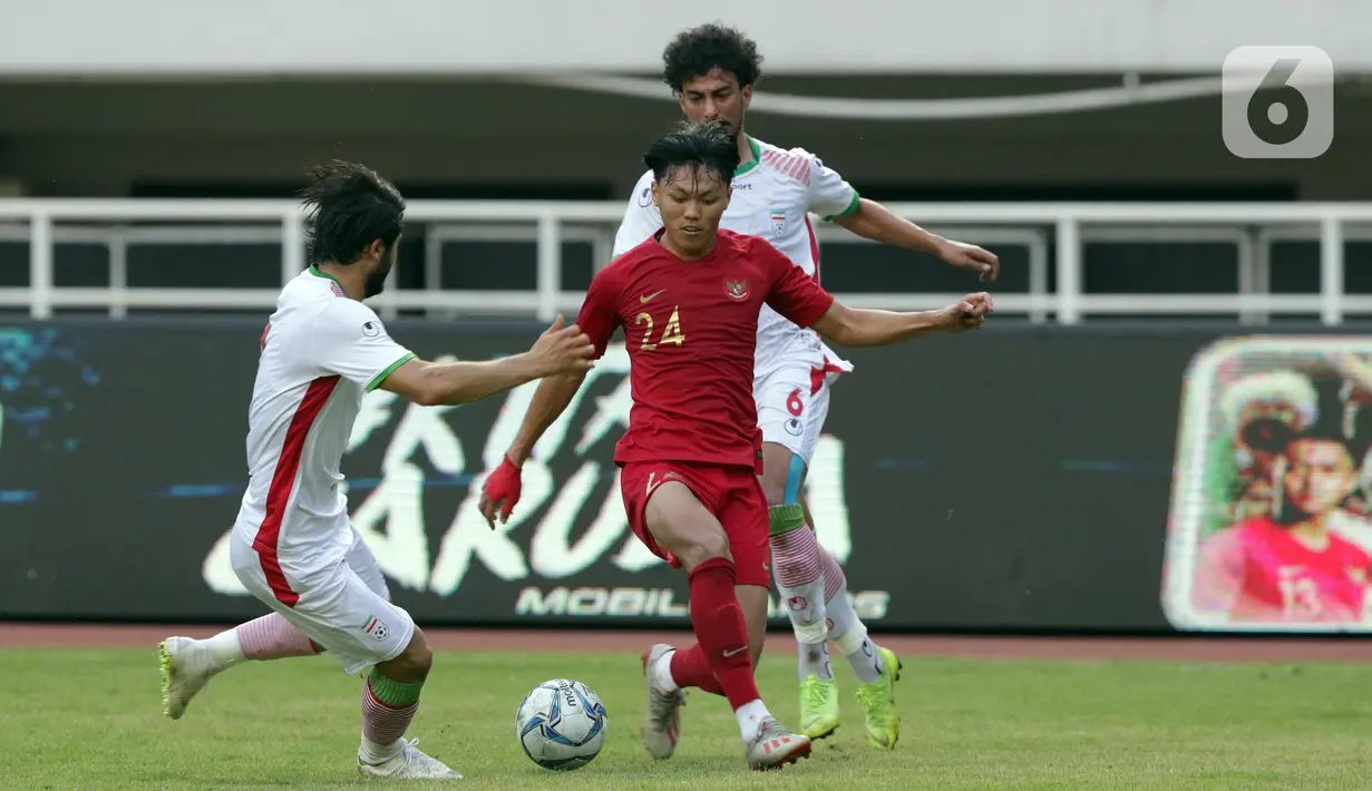 Pemain tengah Timnas Indonesia U-23, Feby Eka Putra (tengah) mencoba melewati adangan pemain Iran U-23 pada laga persahabatan di Stadion Pakansari, Kab Bogor, Sabtu (16/11/2019). Laga ini uji coba terakhir jelang Sea Games Filipina 2019, Indonesia U-23 unggul 2-1. (Liputan6.com/Helmi Fithriansyah)