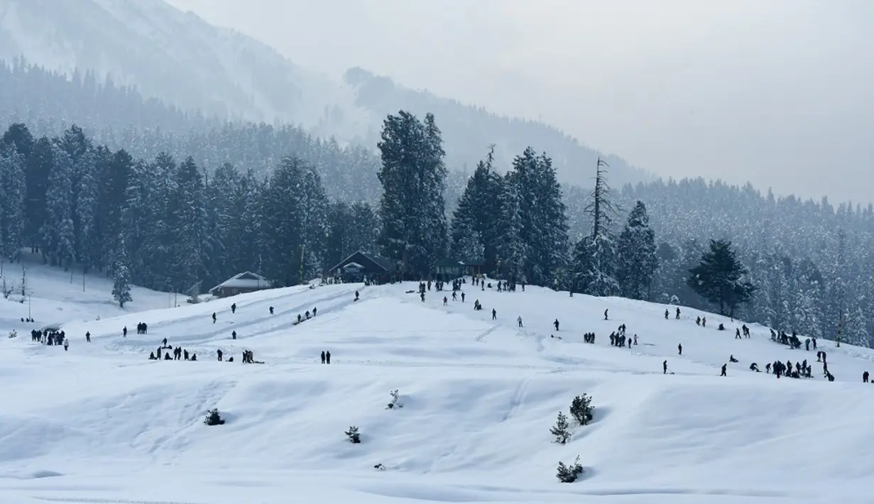 Suasana saat para wisatawan mengunjungi resor ski di Gulmarg, sekitar 55 km utara Srinagar, Jammu dan Kashmir, India, 25 Januari 2021. Gulmarg merupakan destinasi wisata salju di Jammu dan Kashmir. (Tauseef MUSTAFA/AFP)