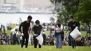 Relawan membersihkan sampah di sebuah taman dekat markas pemerintah setelah demonstrasi menolak RUU ekstradisi di Hong Kong (13/6/2019). Aksi tersebut berujung bentrok antara polisi dan warga dimana puluhan ribu orang memblokir jalan-jalan di kota tersebut. (AFP Photo/Anthony Wallace)