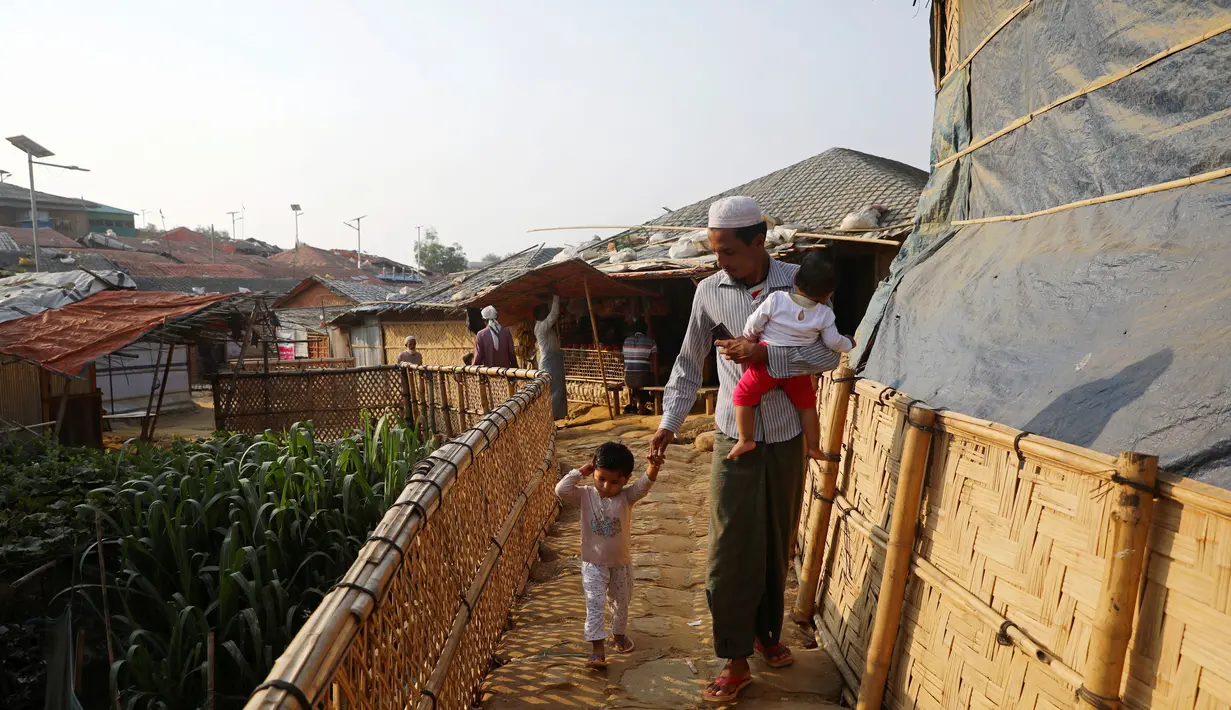 Pengungsi Rohingya berjalan bersama anak-anaknya di kamp Balukhali di Cox's Bazar, Bangladesh( 8/4). Pemerintah Bangladesh mengumumkan berencana memindahkan para pengungsi ke pulau Bhasan Char untuk mengurangi kepadatan di tempat penampungan pengungsi Cox's Bazar. (Reuters/Mohammad Ponir Hossain)