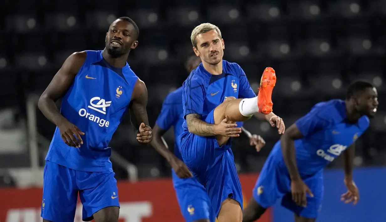 Pemain Prancis Antoine Griezmann (tengah) dan Marcus Thuram (kiri) melakukan pemanasan saat sesi latihan di Stadion Jassim Bin Hamad, Doha, Qatar, 8 Desember 2022. Prancis akan melawan Inggris dalam pertandingan sepak bola perempat final Piala Dunia 2022 pada 10 Desember. (AP Photo/Christophe Ena)